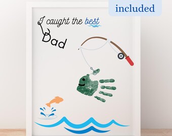 Könnte beinhalten: Ein weißer gerahmter Druck mit einem Handabdruck eines Fisches auf einem blau-weißen Wellenhintergrund. Der Text "Ich habe den besten Papa gefangen" steht über dem Fisch.