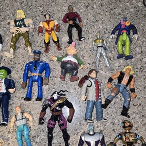 May include: A collection of colorful action figures, featuring various characters in dynamic poses. The figures showcase a range of designs, including superheroes, futuristic characters, and uniformed figures. The toys are made of plastic and are in various colors.
