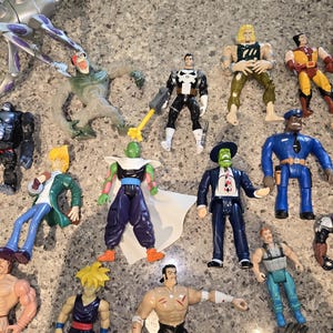 May include: A collection of colorful action figures, including characters from various franchises. The figures are in various poses and feature detailed designs. The figures are made of plastic and are of different sizes.