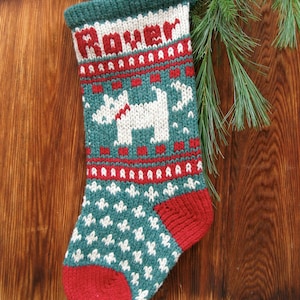 May include: A green and red knitted Christmas stocking with a white dog design and the name "Rover" embroidered on the front.