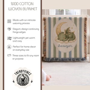 May include: A woven blanket made of 100% cotton featuring vertical blue and beige stripes. The center displays an oval graphic of a green dragon sleeping on a cloud under a crescent moon with the name Sawyer printed below in a cursive script.