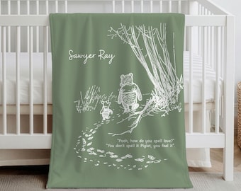Könnte beinhalten: Salbeigrünes Babydecke mit einer weißen Illustration von Winnie Puuh und Ferkel. Die Decke trägt den Namen "Sawyer Ray" und ein Zitat über die Liebe. Die Decke ist über ein weißes Kinderbett drapiert.