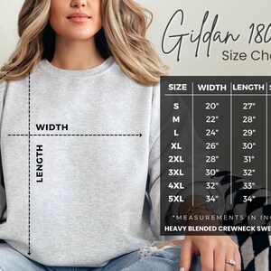 May include: A light gray Gildan 18000 heavy blend crewneck sweatshirt with a size chart. The chart shows measurements in inches for width, length, and sleeve for sizes S through 5XL. The model is wearing the sweatshirt.