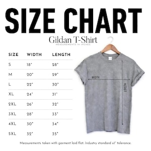 May include: A gray Gildan T-shirt displayed on a wooden hanger, with a size chart showing measurements in inches. The chart lists sizes S to 5XL, with corresponding width and length measurements. The text "SIZE CHART" is at the top.