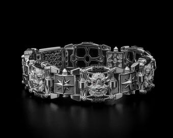 May include: A silver bracelet with intricate details. The bracelet features various geometric shapes, star designs, and animal faces. The links are connected with smaller, textured pieces. The overall design is bold and detailed, with a dark background.