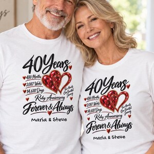Könnte beinhalten: Zwei weiße T-Shirts mit einem grafischen Design, das den Text 40 Years, 480 Months, 2,087 Weeks, 14,610 Days, Ruby Anniversary, Forever & Always und Maria & Steve sowie zwei ineinander verschlungene rote Herzillustrationen zeigt.