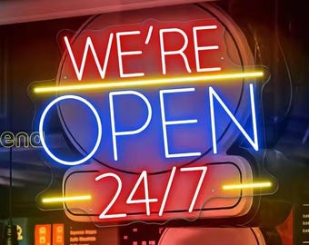 May include: A neon sign with the words "WE'RE OPEN 24/7" in white, blue, and red. The sign is in a window, with a blurred background of a restaurant or shop interior.