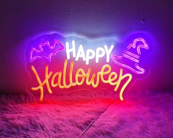 May include: A neon sign with the words "Happy Halloween" in white and orange lettering. The sign also features a purple bat and a witch's hat.