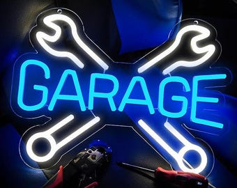 May include: White neon sign with two crossed wrenches and the word "GARAGE" in blue neon letters.