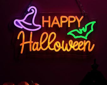 May include: A neon sign with the words "HAPPY Halloween" in orange script, a purple witch hat, and a green bat. The sign is hanging against a dark background, with carved pumpkins at the bottom.