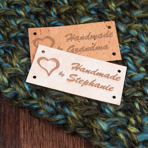 May include: Two cork fabric labels with a heart design and the text "Handmade by Grandma" and "Handmade by Stephanie".