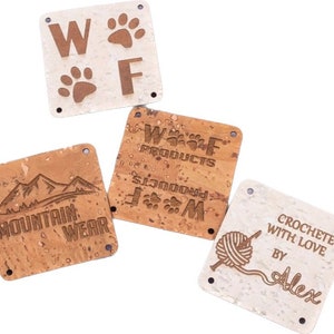 May include: Four square cork labels with different designs. The first label is white with brown paw prints and the letters "W" and "F". The second label is brown with the text "W.O.F. PRODUCTS" and a paw print. The third label is brown with the text "MOUNTAIN WEAR" and a mountain range. The fourth label is white with the text "CROCHETED WITH LOVE BY Alex" and a yarn ball and needle.