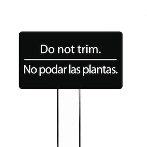 May include: Black garden sign with white text that reads "Do not trim. No podar las plantas."