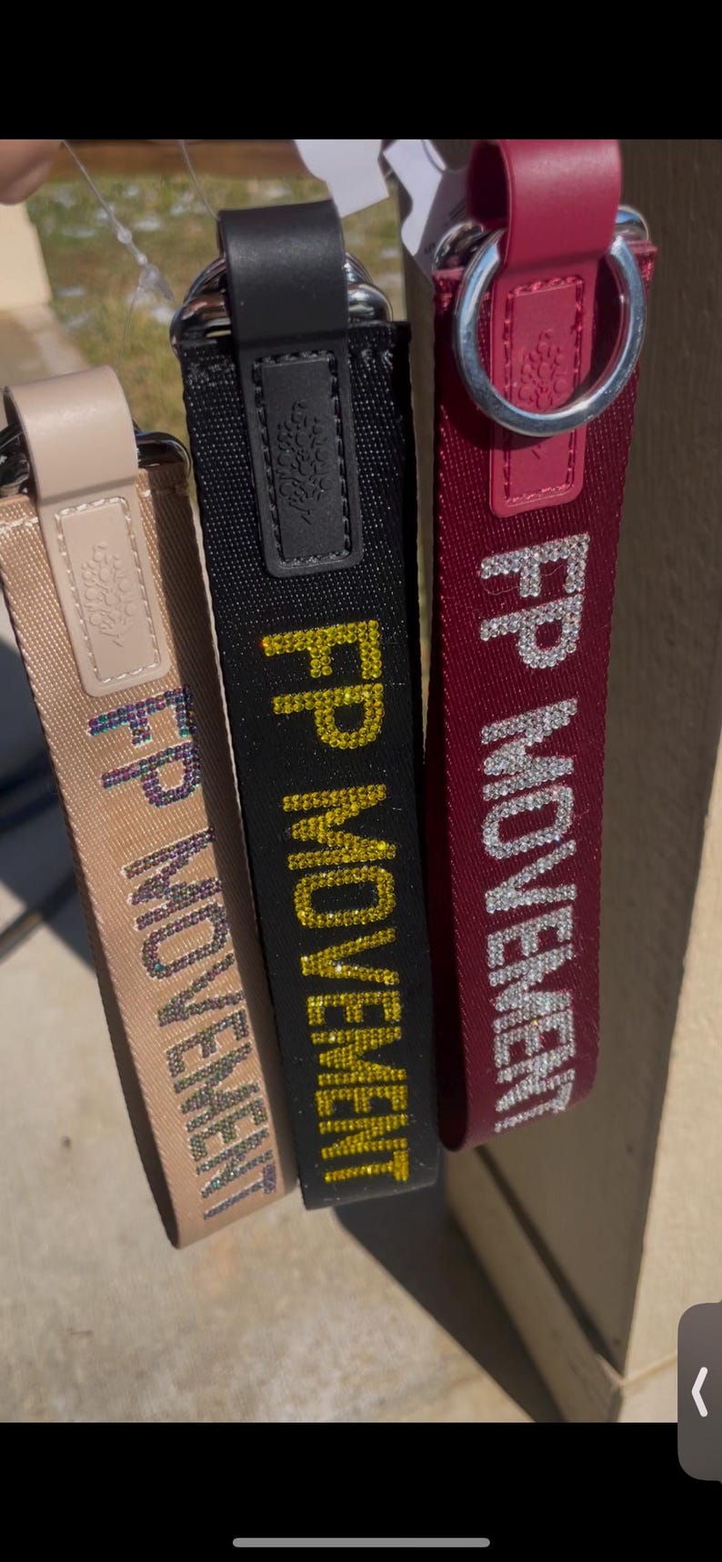 Pu&ograve; includere: Tre portachiavi in tessuto nero, bordeaux e beige con anelli argentati. Ogni portachiavi presenta il testo "FP MOVEMENT" in strass.