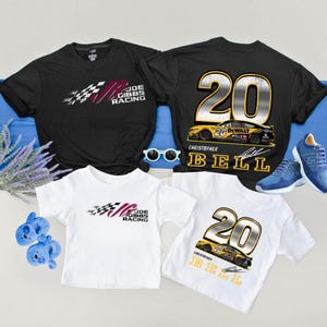 May include: Black and white t-shirts with racing-themed graphics. One shirt features the text "JOE GIBBS RACING" with a checkered flag design. Another shirt displays the number "20" and a race car, with the name "CHRISTOPHER BELL".