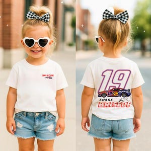 May include: A child wearing a white t-shirt with a racing car design. The front of the shirt has the name "BRISCOE" and a logo. The back of the shirt features the number "19", a race car graphic, and the name "CHASE BRISCOE". The child is also wearing denim shorts.