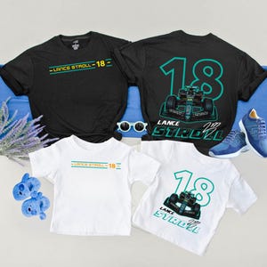 May include: Black and white t-shirts with the text "LANCE STROLL - 18" and a race car graphic. The shirts are displayed with blue sneakers, sunglasses, and baby shoes. The shirts are available in black and white.