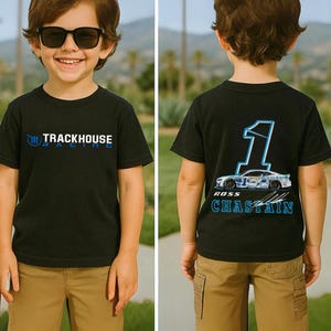 Puede incluir: Camiseta negra de manga corta con el texto "TRACKHOUSE RACING" en azul en la parte delantera. La parte trasera de la camiseta presenta un gran número 1, un gráfico de coche de carreras y el nombre "ROSS CHASTAIN" en azul.