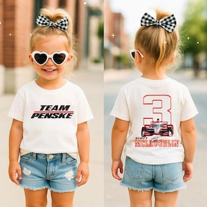 May include: A white t-shirt with the text "TEAM PENSKE" in black and red on the front. The back of the shirt features a large red number 3 with a race car graphic and the name "SCOTT MCLAUGHLIN" in red.