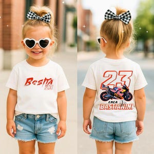 Könnte beinhalten: Ein Kind trägt ein weißes T-Shirt und Jeansshorts. Auf der Vorderseite des T-Shirts steht "Besita" in roter Schrift mit der Nummer 23. Auf der Rückseite des T-Shirts befinden sich die Nummer 23, eine Motorradgrafik und der Name "Enea Bastianini".