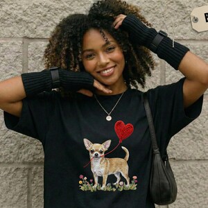 Faux Yarn Chihuahua shirt, puppy love shirt, yarn heart balloon, valentine dog tee style for tiny-dog fans. A cute Chihuahua with big ears holding a red yarn heart balloon string, finished with soft floral details for everyday wear.