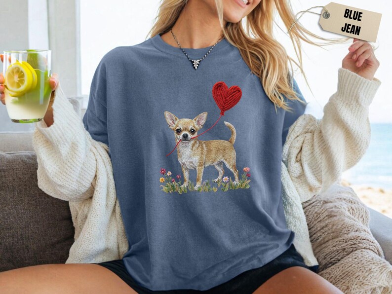 Faux Yarn Chihuahua shirt, puppy love shirt, yarn heart balloon, valentine dog tee style for tiny-dog fans. A cute Chihuahua with big ears holding a red yarn heart balloon string, finished with soft floral details for everyday wear.