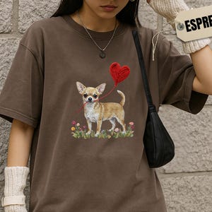 Faux Yarn Chihuahua shirt, puppy love shirt, yarn heart balloon, valentine dog tee style for tiny-dog fans. A cute Chihuahua with big ears holding a red yarn heart balloon string, finished with soft floral details for everyday wear.