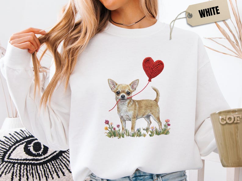 Faux Yarn Chihuahua shirt, puppy love shirt, yarn heart balloon, valentine dog tee style for tiny-dog fans. A cute Chihuahua with big ears holding a red yarn heart balloon string, finished with soft floral details for everyday wear.
