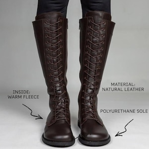 May include: A pair of dark brown knee-high boots featuring a full-length front lace-up design with matching laces. The boots have a polyurethane sole and are lined with warm fleece. Text on the image indicates: MATERIAL: NATURAL LEATHER.
