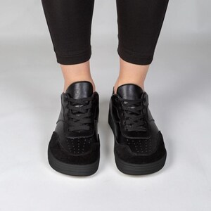 A pair of black sneakers with a sleek, modern design.