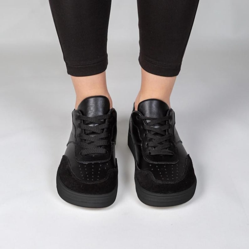A pair of black sneakers with a sleek, modern design.