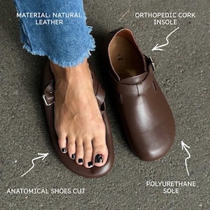 May include: Brown leather clogs with an orthopedic cork insole and polyurethane sole. The clogs have an anatomical shoe cut and a buckle closure. The material is natural leather.
