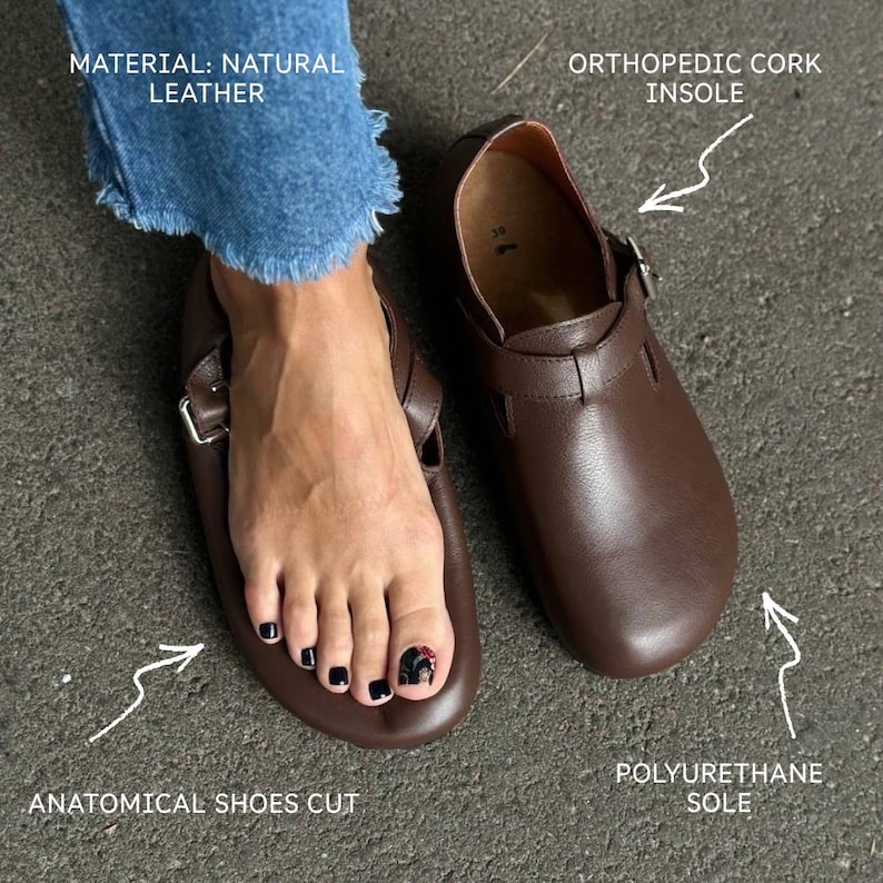 May include: Brown leather clogs with an orthopedic cork insole and polyurethane sole. The clogs have an anatomical shoe cut and a buckle closure. The material is natural leather.
