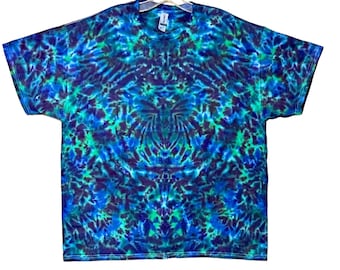 以下が含まれることがあります： 青、緑、紫の渦巻き模様のタイダイTシャツです。