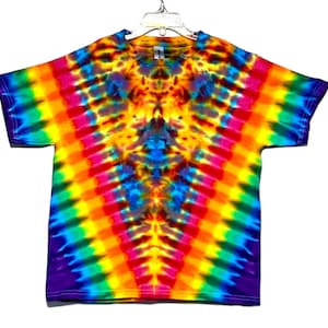 May include: A tie-dye t-shirt with a rainbow pattern in shades of purple, blue, green, yellow, orange, and red. The shirt has a V-shaped design with a darker center.