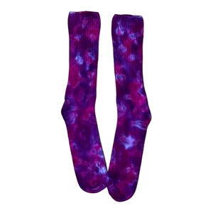 May include: A pair of purple and pink tie-dye socks. The socks are made of a soft, comfortable material and have a unique, colorful design.