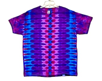 May include: A tie-dye t-shirt with a vertical pattern of blue, pink, and purple. The shirt has a crew neck and short sleeves.