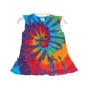 Może przedstawiać: Sukienka bez rękawów w stylu tie-dye z falbaną u dołu. Sukienka jest w odcieniach niebieskiego, zielonego, pomarańczowego, czerwonego i fioletowego.