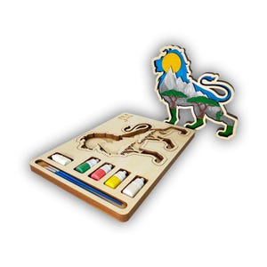 May include: A wooden lion puzzle with a matching lion cutout. The puzzle includes a paint palette with a paintbrush and paint tubes in white, green, red, and yellow. The lion cutout features a blue sky, yellow sun, and green trees.