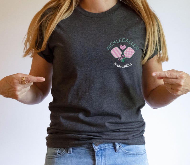 Pu&ograve; includere: T-shirt grigio scuro con un disegno ricamato di racchette da pickleball, un cuore e le parole "Pickleballer" e "Samantha". La maglietta &egrave; realizzata in materiale morbido e ha maniche corte.