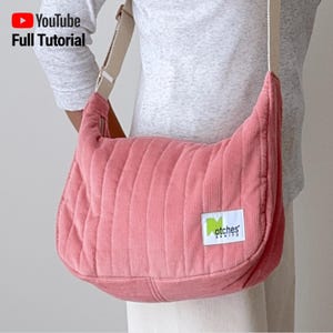 May include: A pink corduroy shoulder bag with vertical quilted stitching. The bag has a cream-colored strap and a small rectangular label with the word "otches" on it. The YouTube logo and the words "Full Tutorial" are in the upper left corner.