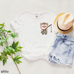 Pesca de cerdo, muchos dibujos animados de peces en la parte posterior de la camiseta con un lindo cerdo en el frente de la camiseta, ¡adecuada para cualquier ocasión!