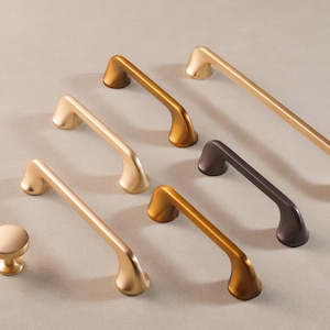 Puede incluir: Surtido de herrajes para armarios en acabados dorado y negro. El herraje incluye tiradores y pomos en varios tamaños y estilos.