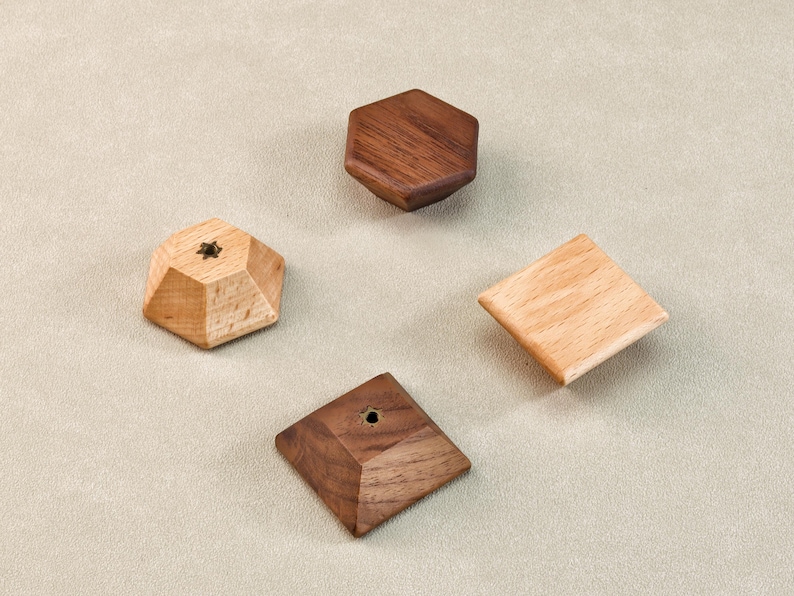 Może przedstawiać: Cztery drewniane kształty geometryczne: sześciokąt, kwadrat i wieloaspektowy kształt, wszystkie w naturalnych odcieniach drewna. Jeden kształt ma mały detal w kształcie gwiazdy. Kształty są ułożone na neutralnym tle.