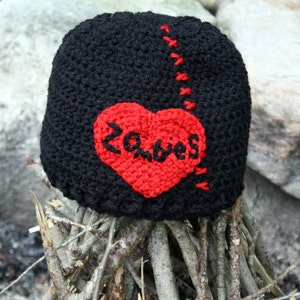Könnte beinhalten: Schwarze Häkelmütze mit einem roten Herz, auf dem "Zombies" steht.