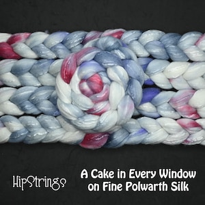 Puede incluir: Primer plano de un producto de fibra trenzada en tonos blancos, azules y rosas. El texto "HipStrings" está en la esquina inferior izquierda y "A Cake in Every Window on Fine Polwarth Silk" en la esquina inferior derecha.