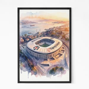 May include: Watercolor painting of a stadium with the text "Tüpraş Stadyumu" on the roof. The stadium is surrounded by a city and water, with a sunset in the background. The artwork is framed in a black frame.