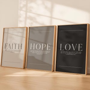 May include: Three framed prints with the words "FAITH", "HOPE", and "LOVE" in large, white text. Each print has a different background color: light beige, gray, and black. The prints also include smaller text with Bible verses.