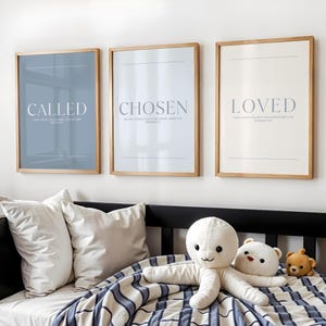 Puede incluir: Tres impresiones enmarcadas con las palabras "CALLED", "CHOSEN" y "LOVED". Las impresiones tienen un marco de madera clara y se exhiben sobre una cama con almohadas y peluches. La impresión "CALLED" tiene un fondo azul.