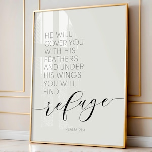 Może przedstawiać: Oprawiony wydruk ze złotą ramą zawiera tekst "HE WILL COVER YOU WITH HIS FEATHERS AND UNDER HIS WINGS YOU WILL FIND refuge" czarnym skryptem. Tekst jest umieszczony na jasnoszarym tle. Odniesienie do Pisma Świętego "PSALM 91:4" znajduje się na dole.